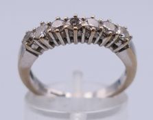 An 18 ct white gold and seven stone diamond ring. Ring size N. 4.2 grammes total weight.