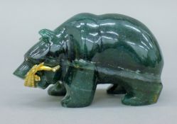 A jade model of a bear holding a silver gilt sturgeon in its mouth. 11 cm long.