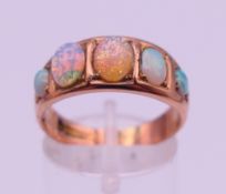 A 9 ct gold and opal five-stone ring. Ring size P/Q. 4.7 grammes total weight.