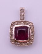 A 9 ct white gold and ruby pendant. 1.5 cm high including suspension loop. 1.