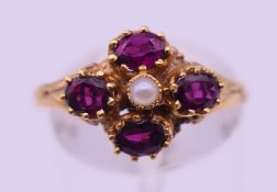A 12 ct gold, garnet and seed pearl ring. Ring size O. 2.1 grammes total weight.