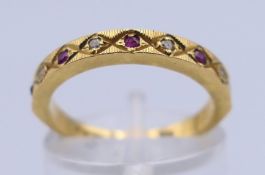 A gold, ruby and diamond half hoop eternity ring. Ring size L. 3.1 grammes total weight.