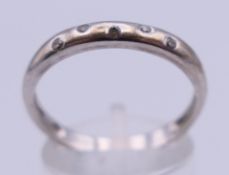 An 18 K white gold and five-stone diamond half eternity ring, stamped 750 and D 0.9. Ring size T. 3.
