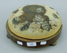 A Victorian beadwork stool, the top decorated with a dog. 28 cm diameter.