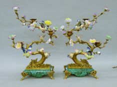 A pair of porcelain and gilt metal candelabra, each surmounted with bird and flowers.