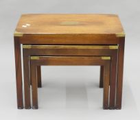 A nest of three mahogany campaign-style coffee tables. 64 cm wide.