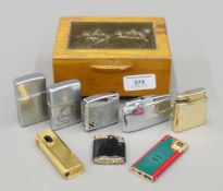 A collection of vintage lighters, including Ronson and Colibri, housed in a brass-mounted oak box.