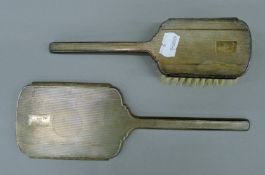 A silver dressing table mirror and brush. The former 27 cm high.