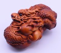 A wooden carving of a dragon. 8 cm long.