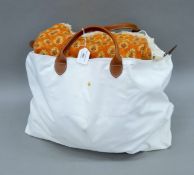 A Longchamp travel bag containing various linen, fabrics, etc. The bag 55 cm wide.
