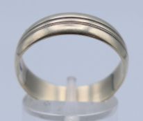 A 9 ct white gold wedding band. Band 6 mm high, ring size U/V. 4.5 grammes.
