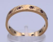 A 9 ct gold and ruby set eternity ring. Ring size O. 2.7 grammes total weight.