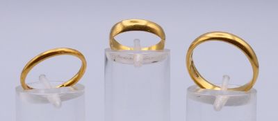 Three 22 ct gold wedding bands, one hallmarked BRAVINGTONS.