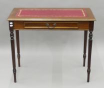 A leather-topped mahogany writing table. 91 cm wide.