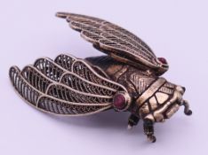 A metal cicada with filigree wings. 6 cm long.