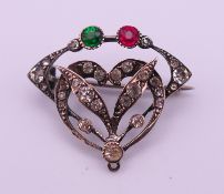 A French Art Nouveau brooch with clear, green and red stones, stamped DEPOSE. 3 x 2.5 cm.