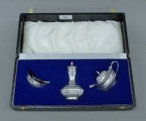A cased three-piece silver cruet set. The case 31 cm wide. 166.5 grammes.