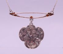 A silver Art Nouveau style necklace with clover shaped pendant depicting a maiden with scrolling