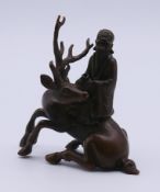 A bronze model of a Shou Lao astride a deer. 7 cm high.