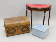 A small blue ottoman, a tin trunk and a leather-topped side table. The latter 81.5 cm wide.