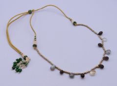 An Indian lariat seed pearl adjustable necklace with multi-coloured drop. Maximum length 90 cm.