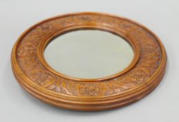 A Victorian carved walnut wall glass. 31.5 cm diameter.