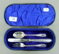 A cased silver three-piece Christening set. The case 24.5 cm wide. 100.8 grammes total weight.