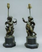 A pair of white metal lamps formed as cherubs, each mounted on a wooden plinth base.