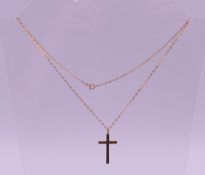 A 9 ct gold cross pendant on a 9 ct gold chain. Cross 3 cm high, chain 46 cm long. 3.7 grammes.