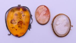 Two yellow metal mounted cameo brooches and a large white metal mounted pendant (lacking suspension