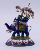 An Indian enamel decorated model of an elephant with howdah and riders. 6.5 cm high.