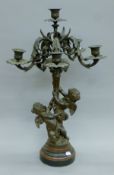 A bronze candelabra decorated with cherubs. 69 cm high.