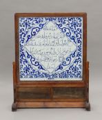 A Chinese wooden-framed blue and white porcelain table screen decorated with Arabic script.