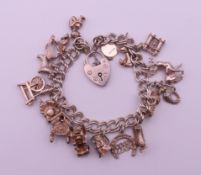 A silver charm bracelet with various charms and a silver padlock fastening. Bracelet 18 cm long. 46.