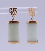 A pair of Chinese unmarked gold mounted jade earrings. 3 cm high. 2.9 grammes total weight.