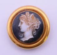 An unmarked high carat gold and hardstone cameo brooch. 2.5 cm diameter. 7.1 grammes total weight.