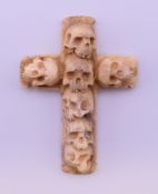 A carved bone skull crucifix. 7 cm high.