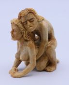 An erotic carved bone figural group. 6 cm high.