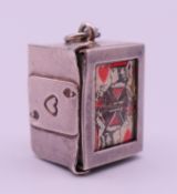 A silver/white metal charm containing a faux miniature pack of playing cards. 1.6 cm high.