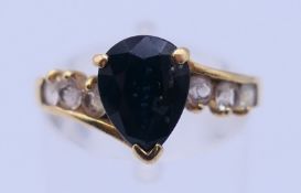 An 18 ct gold ring with pear shaped central stone. Ring size M/N. 2.4 grammes total weight.