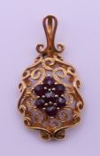 A 9 ct gold and garnet pendant. 3.5 cm high. 4 grammes total weight.