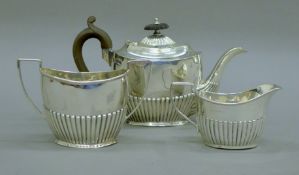 A silver three-piece tea set. The teapot 21 cm long. 403.9 grammes total weight.