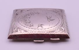 An engraved silver cigarette case. 6.5 cm wide. 67.5 grammes total weight.