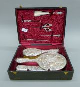 A cased silver dressing table set with associated comb and an extra brush. The case 30.5 cm wide.
