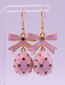 A pair of silver gilt pink enamel egg and bow earrings, bearing Russian marks.
