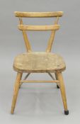 An elm-seated mid 20th century child's pine chair. 59 cm high.