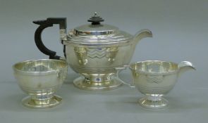 An Art Deco three-piece silver tea set. The teapot 23 cm long. 677.7 grammes total weight.