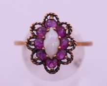 A 9 ct gold, ruby and opal ring. Ring size V/W. 3.2 grammes total weight.