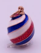 A 14 ct gold and red, white and blue enamelled egg pendant, bearing Russian marks.