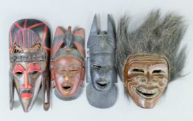 Four African carved wooden tribal masks. The largest 42 cm high.